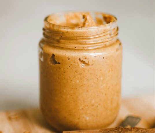 Jar of fresh peanut butter with roasted peanuts